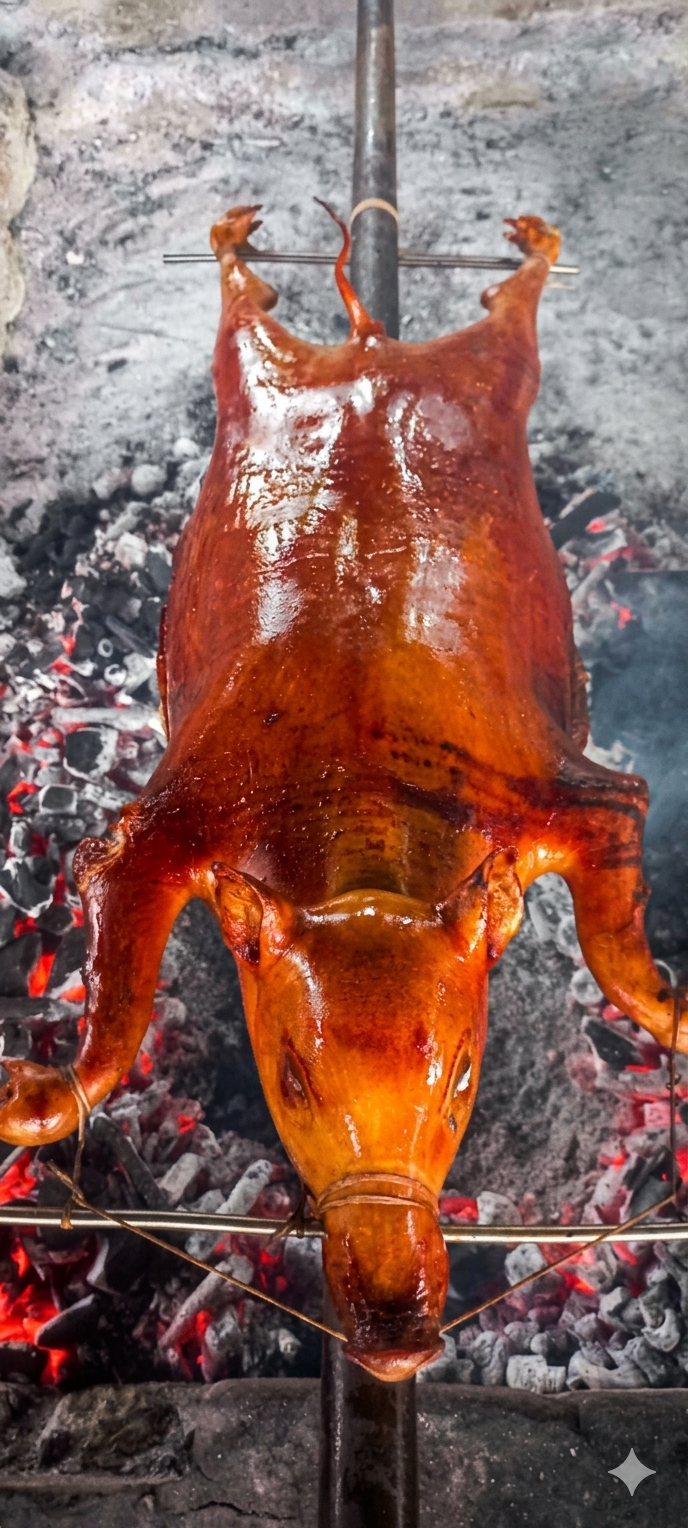 A whole Lechon Cochinillo (suckling pig) roasting to a golden-brown, crispy finish.