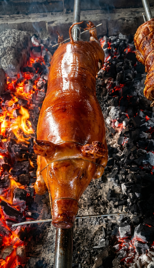 A whole native pig, expertly roasted to a deep, glossy golden-brown.